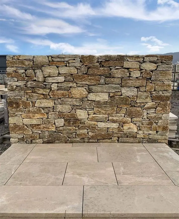 Goldbeige Natursteinmauer mit Travertinplatten — Musterfläche im Lager Einsiedl
